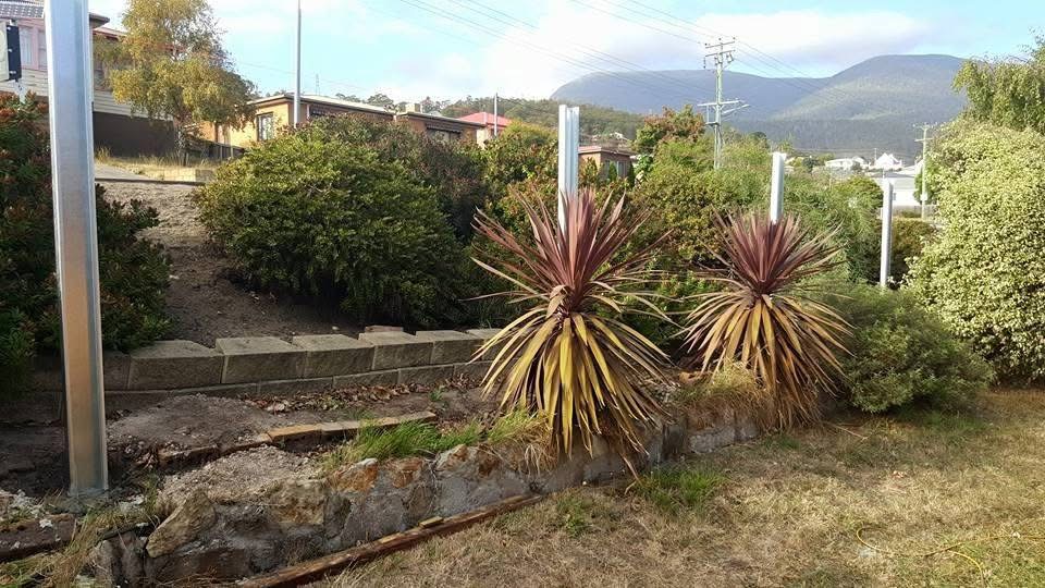 Galvanised steel fence posts set along a sloping suburban boundary