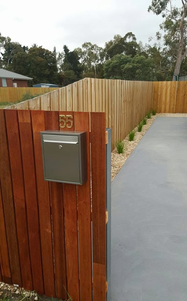 Hardwood feature fence panel with letterbox beside a driveway
