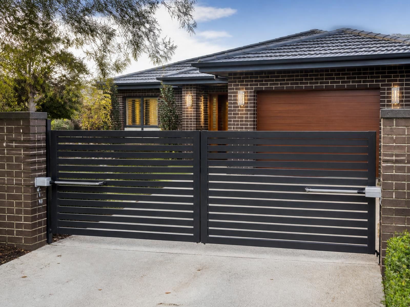 Charcoal horizontal slat automatic driveway gate closed at a brick Australian home